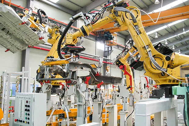 Industrial robot arms working together on an automotive production line
